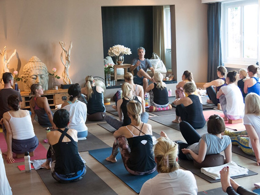 A class of yoga students sitting on mats